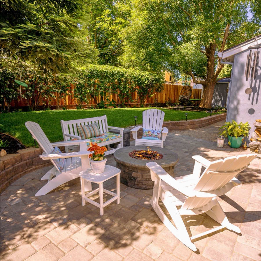 Paver patio with lounge seating under mature trees
