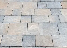 A neatly arranged pattern of square and rectangular stone pavers, showcasing a uniformly designed pavement or patio surface.